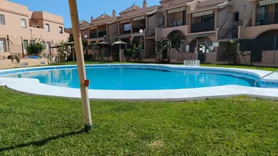 a small pool in the grass with umbrellas at Al Andalus in Chiclana de la Frontera
