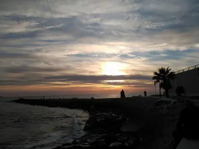a sunset on the beach with the sun setting at Dunas y Luz in Rota