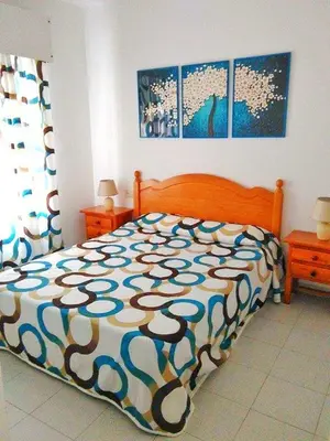 a bedroom with a bed with a colorful comforter at Dunas y Luz in Rota