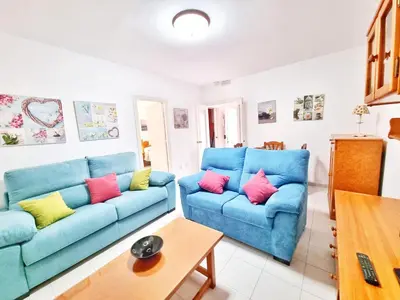 a living room with two blue couches and a table at Dunas y Luz in Rota