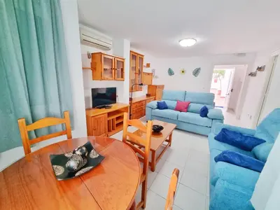 a living room with a table and a blue couch at Dunas y Luz in Rota