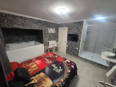 a bedroom with a large bed and a bath tub at Latorre jacuzzi jerez in Jerez de la Frontera