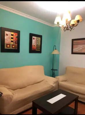 a living room with a couch and a table at Chipiona Apartamento Bajo Centro Parking Incluido WiFi GRATIS in Chipiona