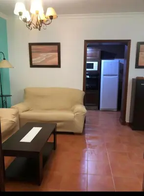 a living room with a couch and a table at Chipiona Apartamento Bajo Centro Parking Incluido WiFi GRATIS in Chipiona