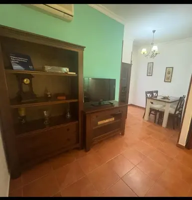 a living room with a tv and a entertainment center at Chipiona Apartamento Bajo Centro Parking Incluido WiFi GRATIS in Chipiona
