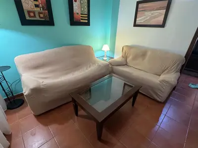 a living room with a couch and a glass coffee table at Chipiona Apartamento Bajo Centro Parking Incluido WiFi GRATIS in Chipiona