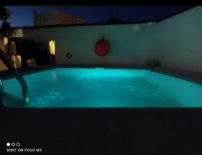a large blue swimming pool at night at Casa del abuelo antonioTrujillo in Conil de la Frontera