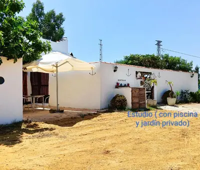 a white house with an umbrella in front of it at Casa del abuelo antonioTrujillo in Conil de la Frontera