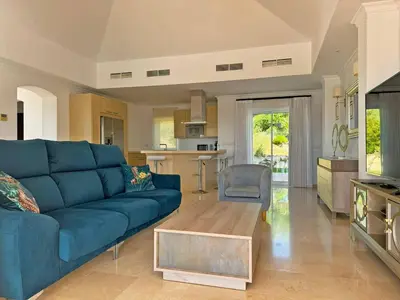 a living room with a blue couch and a table at Villa Los Olivos - Ole Solutions in Arcos de la Frontera