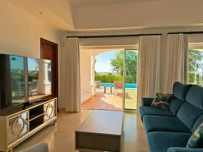 a living room with a blue couch and a tv at Villa Los Olivos - Ole Solutions in Arcos de la Frontera