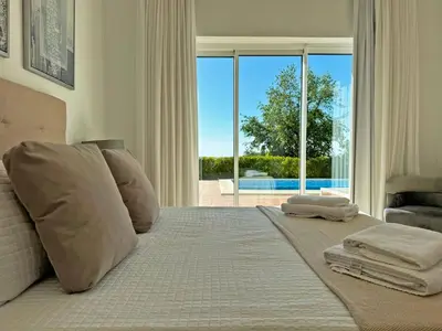 a bedroom with a bed with a view of a pool at Villa Los Olivos - Ole Solutions in Arcos de la Frontera