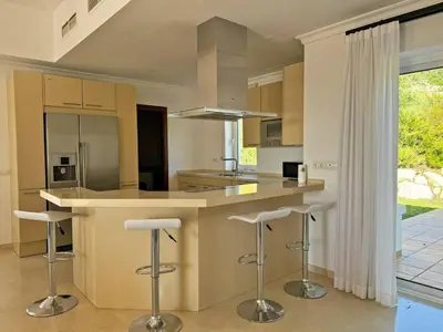 a kitchen with a island with bar stools at Villa Los Olivos - Ole Solutions in Arcos de la Frontera