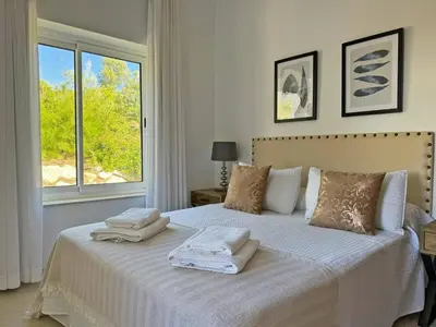 a bedroom with a bed with white sheets and a window at Villa Los Olivos - Ole Solutions in Arcos de la Frontera