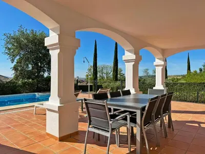 a patio with a table and chairs and a pool at Villa Los Olivos - Ole Solutions in Arcos de la Frontera