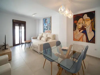 a living room with a glass table and a couch at Piso Torno in Sanlúcar de Barrameda
