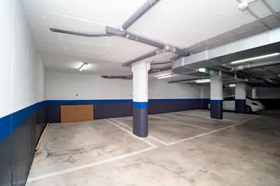 an empty parking garage with white and blue columns at Piso Torno in Sanlúcar de Barrameda