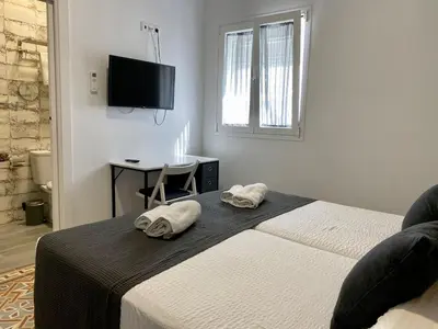 a bedroom with a bed and a desk and a television at Anka Kurro in Rota