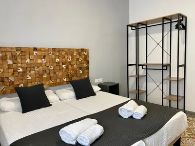 a bedroom with a large bed with towels on it at Anka Kurro in Rota