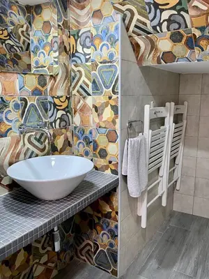a bathroom with a sink and a mosaic wall at Anka Kurro in Rota