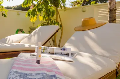 a straw hat sitting on a bed with a blanket at La Casa del Mar in Chiclana de la Frontera