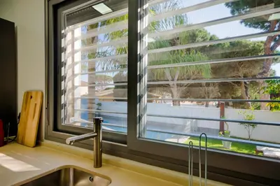 a kitchen with a sink and a window with blinds at La Casa del Mar in Chiclana de la Frontera