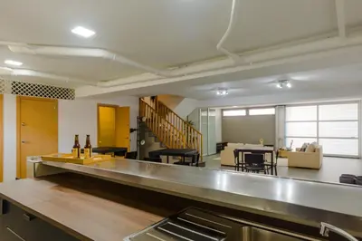 a kitchen with a counter and a living room at La Casa del Mar in Chiclana de la Frontera