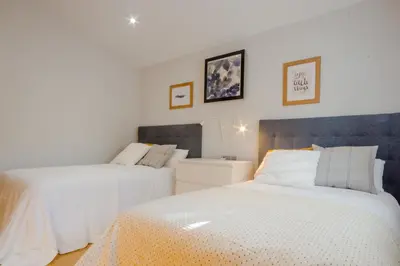 a bedroom with two beds with white sheets at La Casa del Mar in Chiclana de la Frontera