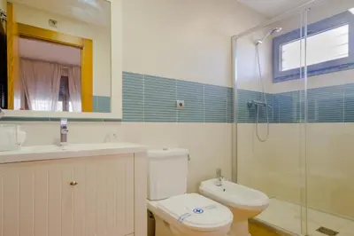 a bathroom with a toilet and a shower and a sink at La Casa del Mar in Chiclana de la Frontera