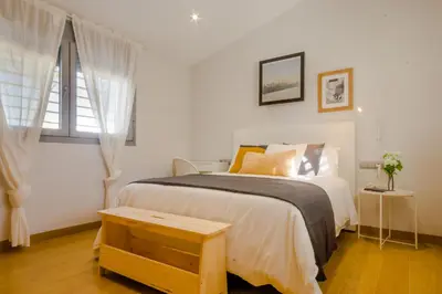 a bedroom with a large bed with a wooden table at La Casa del Mar in Chiclana de la Frontera