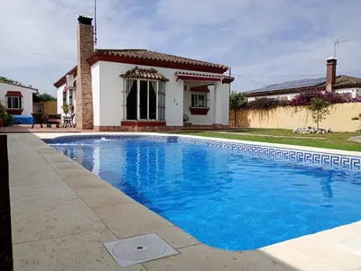 a swimming pool in front of a house at Chalet Pura Vida in Chiclana de la Frontera
