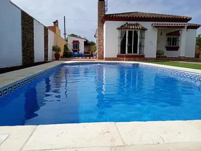 a swimming pool in front of a house at Chalet Pura Vida in Chiclana de la Frontera