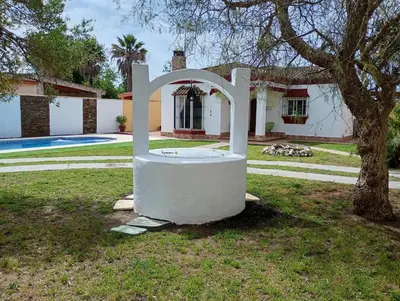 a white object sitting in the grass in front of a house at Chalet Pura Vida in Chiclana de la Frontera
