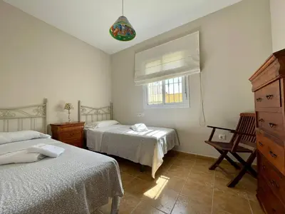 a bedroom with two beds and a window at Chalet Pura Vida in Chiclana de la Frontera
