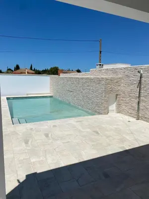 a swimming pool on the side of a brick building at Erika & Julia in Chiclana de la Frontera