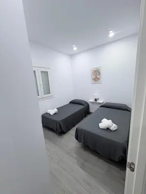 two beds in a room with white walls at Erika & Julia in Chiclana de la Frontera
