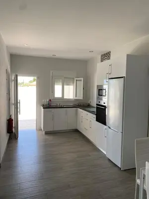 a kitchen with white cabinets and a refrigerator at Erika & Julia in Chiclana de la Frontera