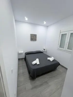 a bedroom with a black bed in a white room at Erika & Julia in Chiclana de la Frontera