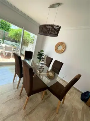 a dining room with a glass table and chairs at Villa Libertad in Conil de la Frontera