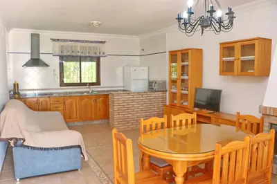 a kitchen and dining room with a table and chairs at Chalet La Florida in Conil de la Frontera