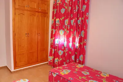 a room with a red curtain and a wooden cabinet at Chalet La Florida in Conil de la Frontera
