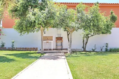 a garden with trees in front of a building at Chalet La Florida in Conil de la Frontera