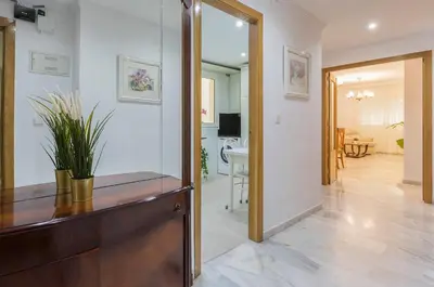 a living room with a wooden dresser and a mirror at Avenida Playa 3 Rooms 2 baños in Cádiz