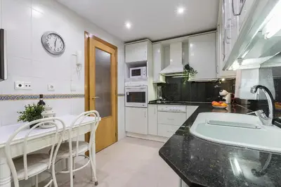 a white kitchen with a sink and a counter at Avenida Playa 3 Rooms 2 baños in Cádiz