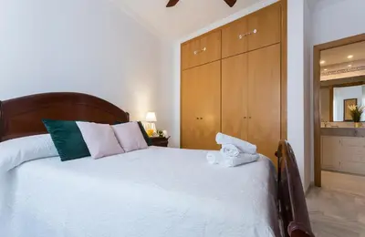 a bedroom with a large white bed with towels on it at Avenida Playa 3 Rooms 2 baños in Cádiz