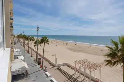 a view of a beach with palm trees and the ocean at ACQUARELA Family Home free parking by Cadiz4Rentals in Cádiz