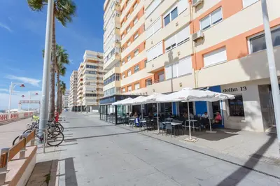 a sidewalk with tables and umbrellas on a building at ACQUARELA Family Home free parking by Cadiz4Rentals in Cádiz