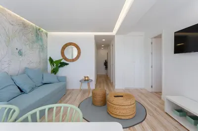 a living room with a blue couch and a table at ACQUARELA Family Home free parking by Cadiz4Rentals in Cádiz