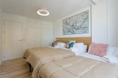 a bedroom with two beds and a painting on the wall at ACQUARELA Family Home free parking by Cadiz4Rentals in Cádiz
