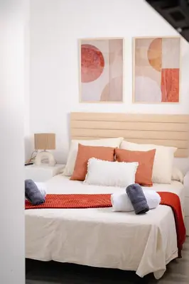 a bedroom with two beds with orange and white pillows at El Tablao in Jerez de la Frontera
