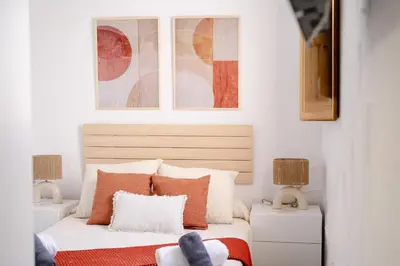 a bedroom with a bed with orange and white pillows at El Tablao in Jerez de la Frontera